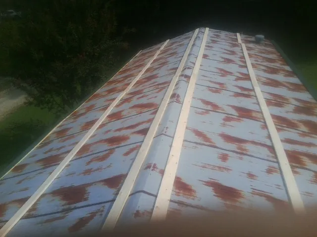 Rusted metal roof panels with new wood purlins before replacement — Storm Damage Roof Repair in Lula by Roofing Brothers